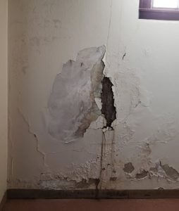 photo of a basement wall crack and water leaking in