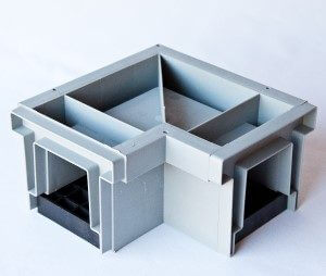 image of a 90 degree Trench Drain - a rectangular 90 degree box with a grid cover